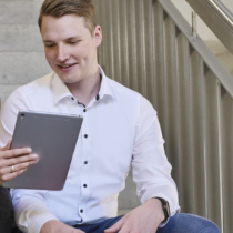 Team members collaborating at a laptop in a modern office, illustrating how a platform company enables efficient digital workflows.